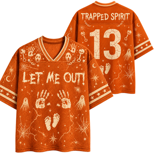 An orange short-sleeve V-neck t-shirt with a distressed white Halloween graphic print featuring ghosts, footprints, handprints, skulls, and the text 'LET ME OUT!' on the front, with 'TRAPPED SPIRIT' and the number '13' on the back.
