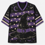 A short-sleeve V-neck t-shirt with a Halloween theme, featuring a large distressed black witch hat graphic on a purple and black striped background with stars, moons, and bats.