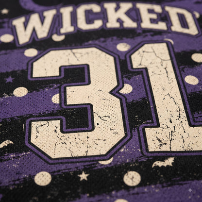 Close-up of a purple and black graphic fabric featuring the word 'WICKED' in distressed cream lettering above the number '31' in cream with purple outlines, decorated with cream stars and dots.