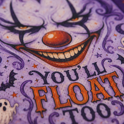 Close-up of a purple Halloween-themed graphic with a creepy clown face, orange nose and lettering, stars, bats, and the phrase “YOU’LL FLOAT TOO.”.